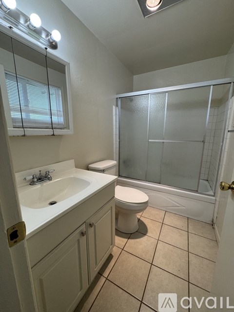 A bathroom with a toilet, sink, and shower.