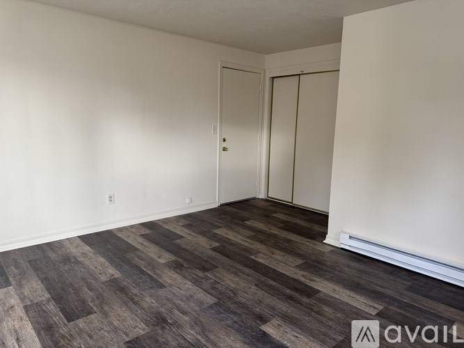 A room with a wooden floor and white walls.