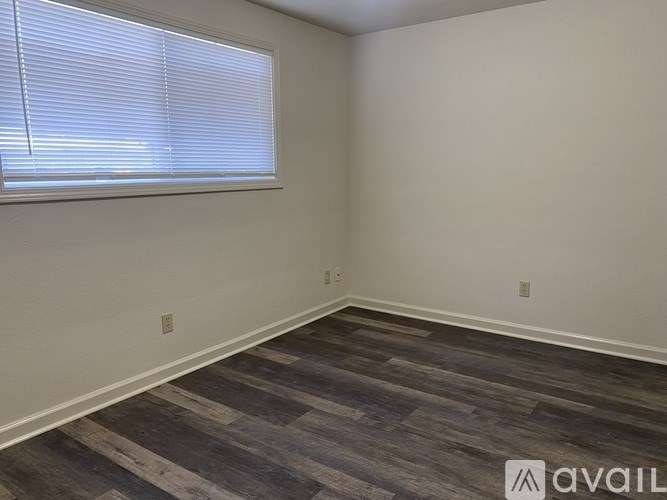 A room with a window and wooden flooring.