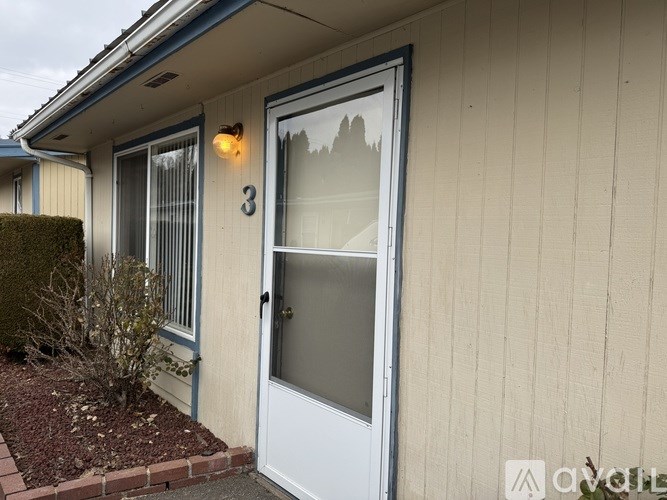 A white door with a glass window is on the right side of the house.