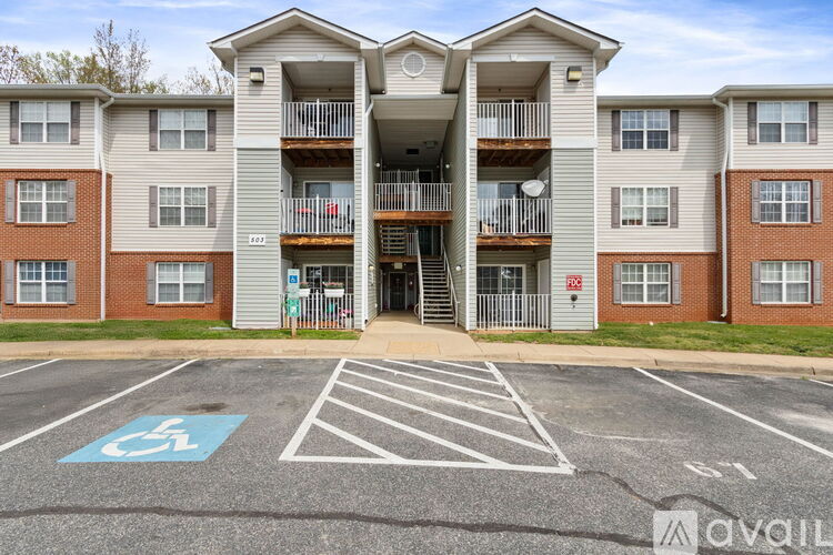 A parking lot in front of a building with a handicap parking space.