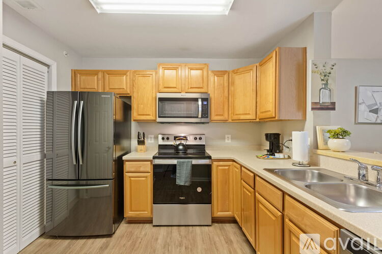 A kitchen with wooden cabinets and a stainless steel refrigerator.