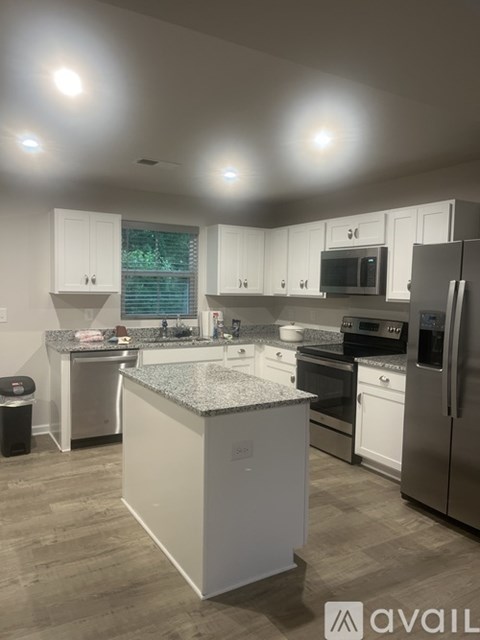 A kitchen with a granite island in the middle.
