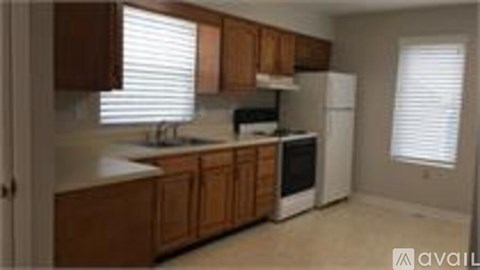 A kitchen with wooden cabinets and white appliances.