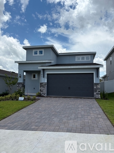 A house with a grey garage door is for sale.
