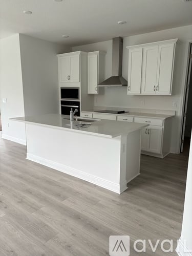 A kitchen with white cabinets and a large island.