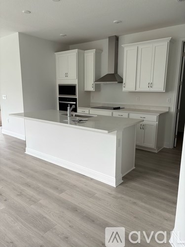 A kitchen with white cabinets and a large island.