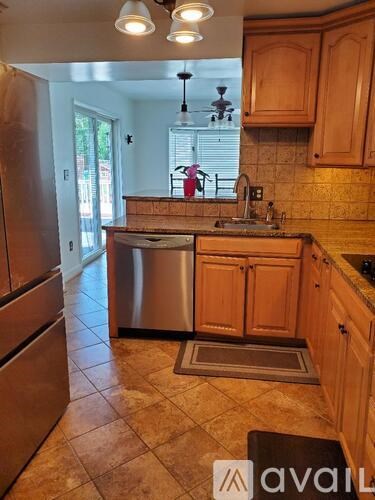 A kitchen with wooden cabinets and a stainless steel dishwasher.