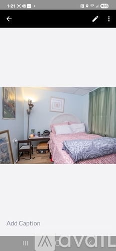 A bedroom with a bed, desk, and chair.