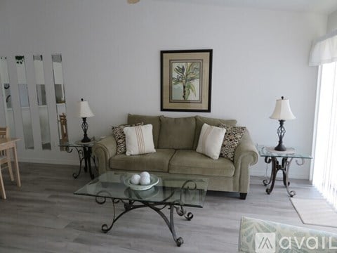 A living room with a couch, two lamps, and a painting on the wall.