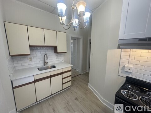 A kitchen with white cabinets and a black stove top oven.