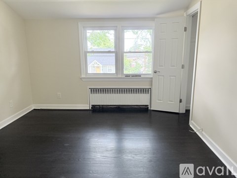 A room with a window and a radiator on the floor.