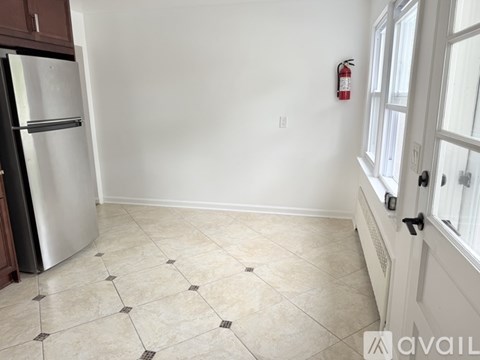 A kitchen with a tiled floor and a fire extinguisher on the wall.