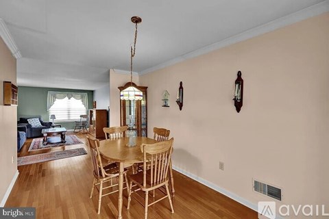 A dining room with a wooden table and chairs.
