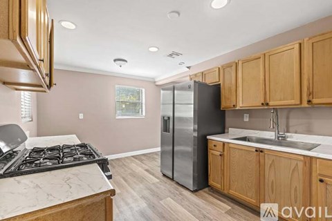 A kitchen with wooden cabinets and a black stove top.