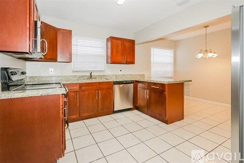 A kitchen with brown cabinets and a granite countertop.