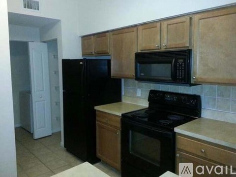 A kitchen with black appliances and wooden cabinets.
