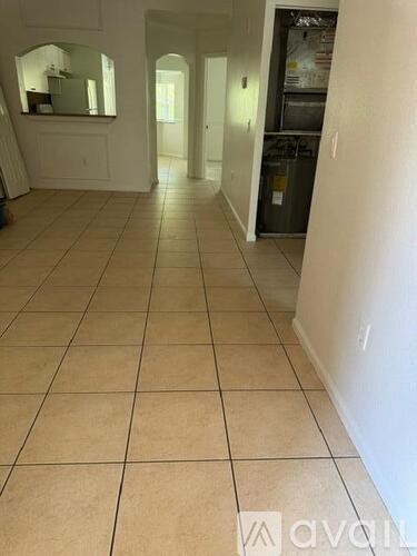 A kitchen with white cabinets and a tile floor.
