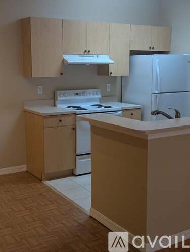 A kitchen with a white fridge, white stove, and white oven.