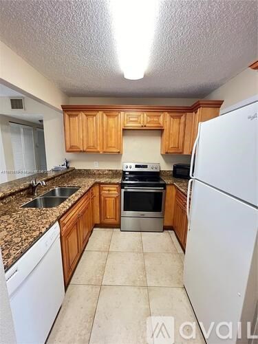 A kitchen with wooden cabinets and a white refrigerator.