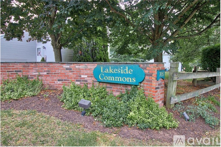 A sign that says Lakeside Commons in front of a brick wall.