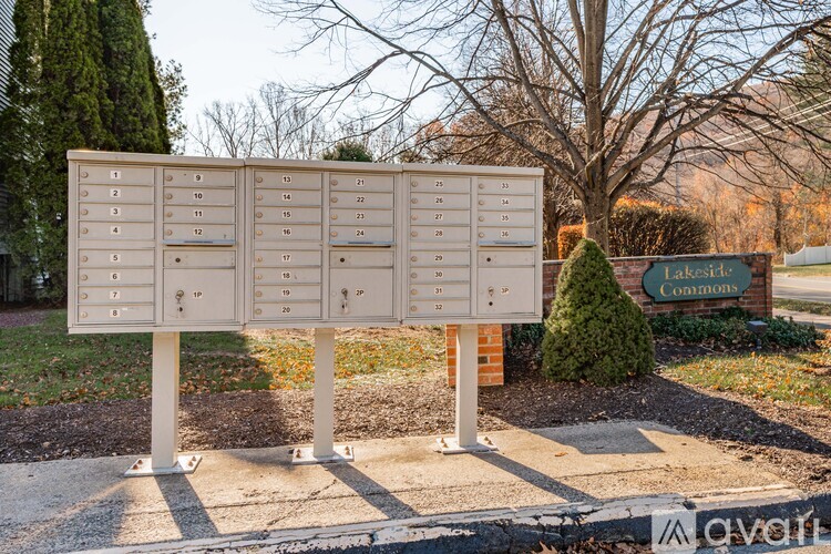 A sign with numbered boxes is in front of a lakeside commons sign.