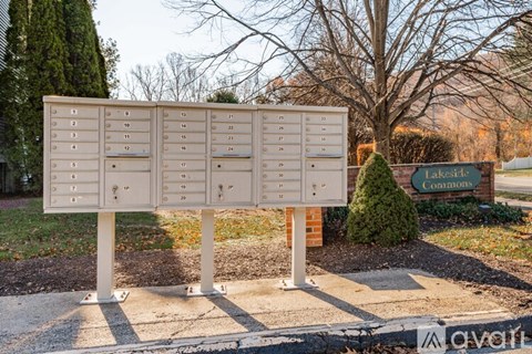 A sign with numbered boxes is in front of a lakeside commons sign.