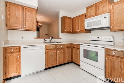 A kitchen with wooden cabinets and white appliances.