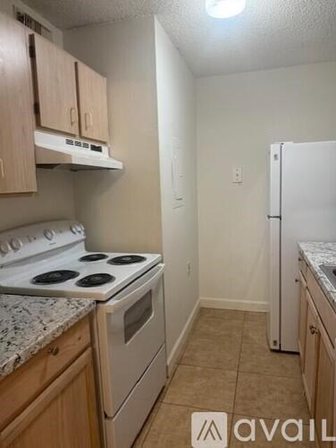 A kitchen with a stove top oven and a refrigerator.