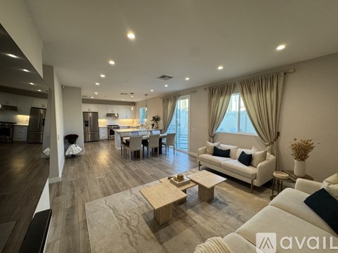 A spacious living room with a white sofa and wooden coffee table.