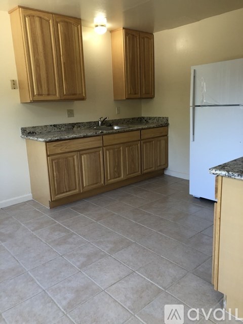 A kitchen with wooden cabinets and a granite countertop.