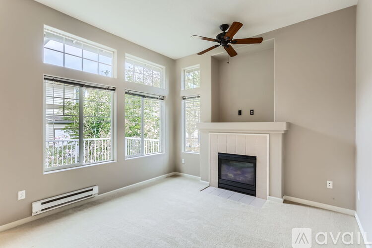 A living room with a fireplace and a ceiling fan.