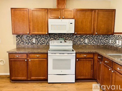 A kitchen with wooden cabinets and a white oven.