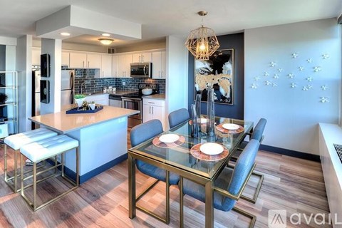 A modern kitchen with a glass dining table and chairs.