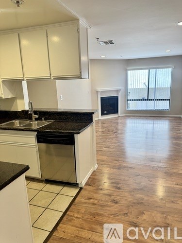 A kitchen with white cabinets and a black countertop.