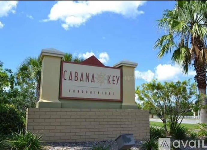 A sign that says "CABANA KEY" in front of a palm tree.