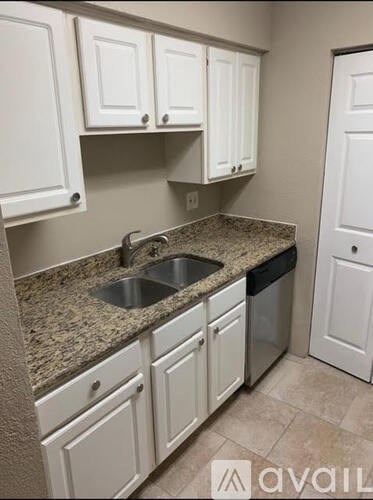 A kitchen with granite countertops and white cabinets.