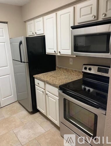 A kitchen with black appliances and white cabinets.