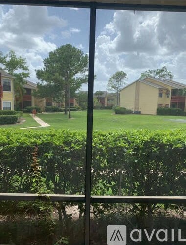 A view of a residential area through a window with the word "AVAIL" on the glass.