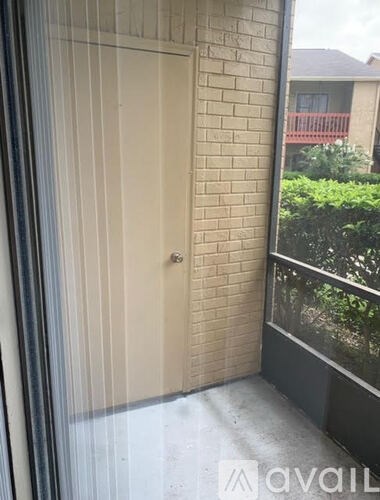 A view of a balcony with a door and a window.