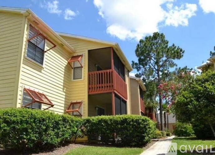 A yellow house with a balcony and a red railing.
