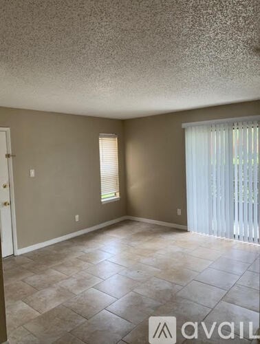 A room with a tile floor and a window with blinds.