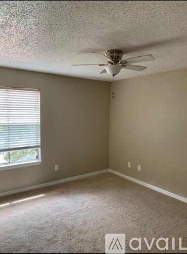 A room with a fan and a window.