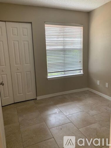A room with a door, window, and tiled floor.