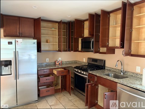 A kitchen with brown cabinets and a stainless steel refrigerator.
