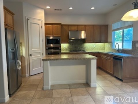 A kitchen with a granite countertop and stainless steel appliances.