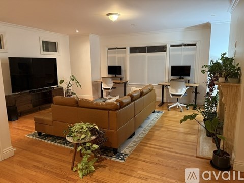 A living room with a brown couch and a television.