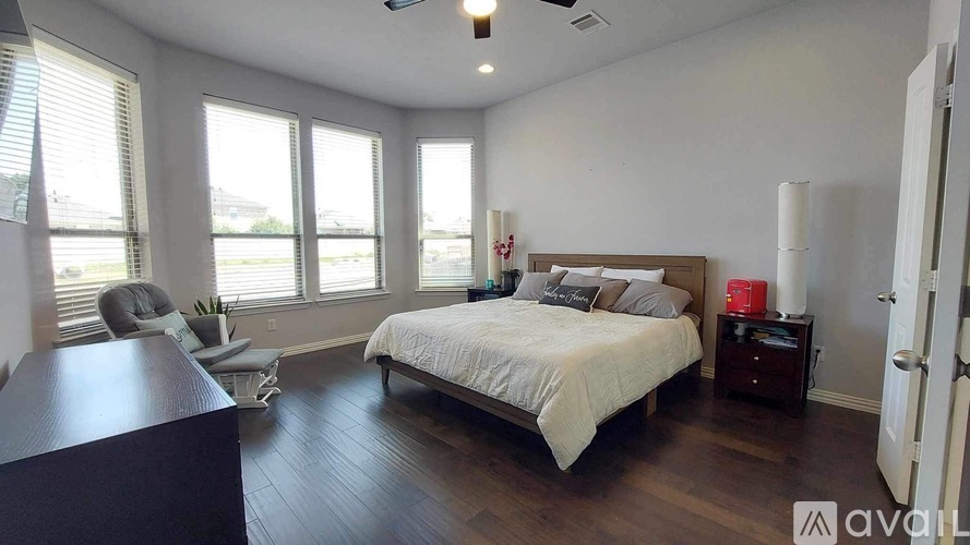 A bedroom with a large bed and a desk.