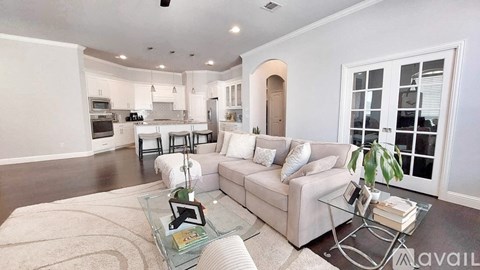 A modern living room with a glass coffee table and a white sofa.
