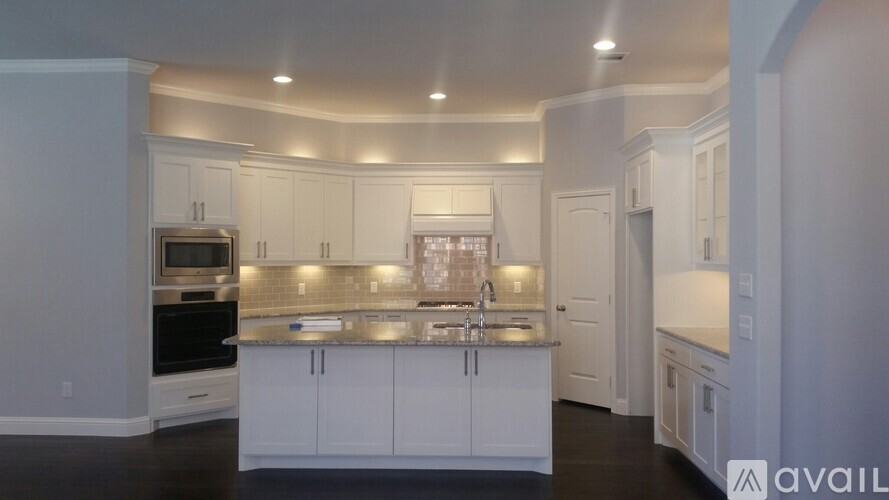 A kitchen with white cabinets and a center island.